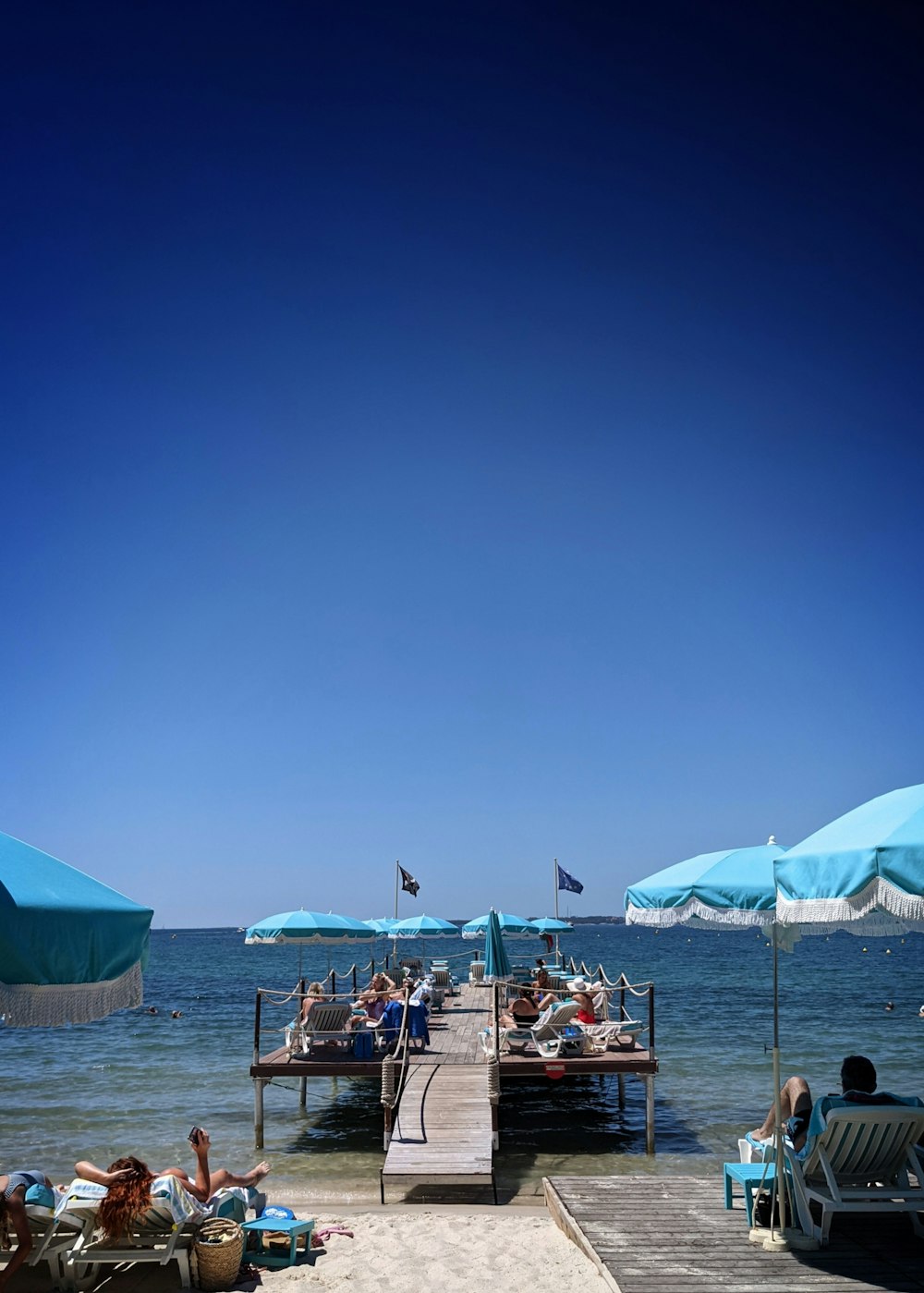 people sitting on beach chairs under blue sky during daytime