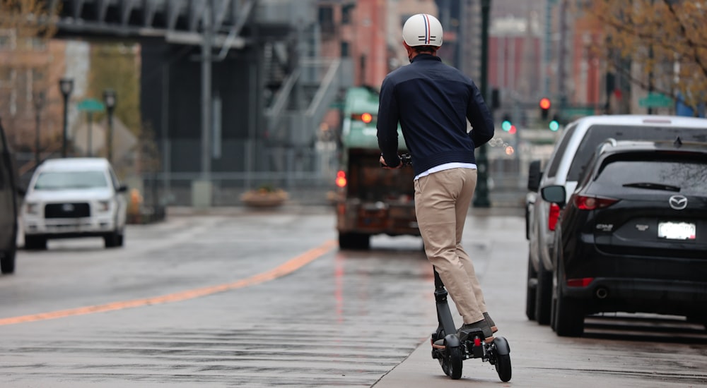 man in blue long sleeve shirt and brown pants wearing black shoes running on street during