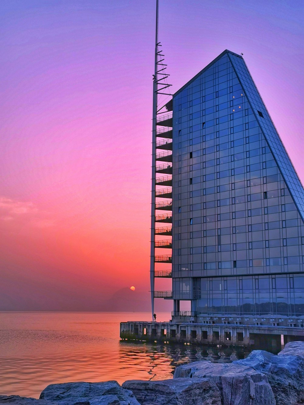 glass building near body of water during sunset
