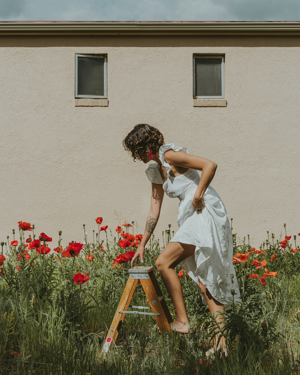 a woman in a white dress climbing a ladder