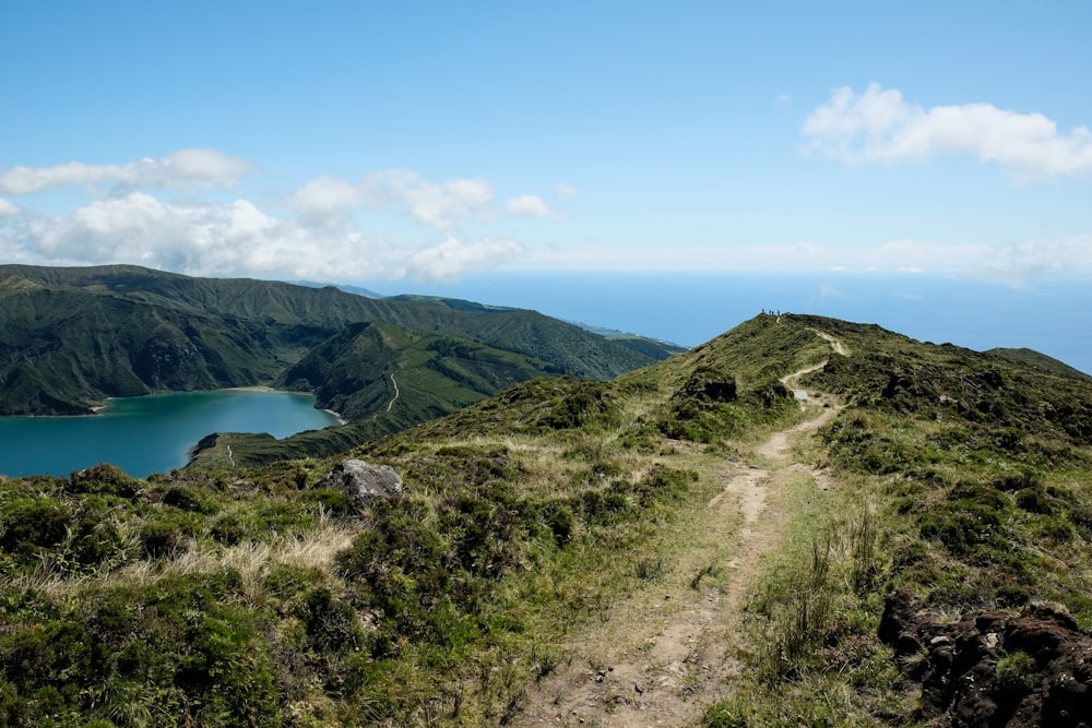 green mountains near lake under blue sky during daytime