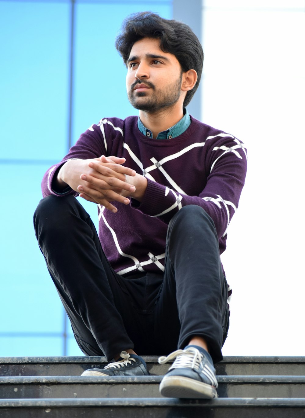 man in black and red long sleeve shirt and black pants sitting on blue chair