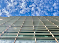 Wide angle shot of a glass facade installation under bright blue sky