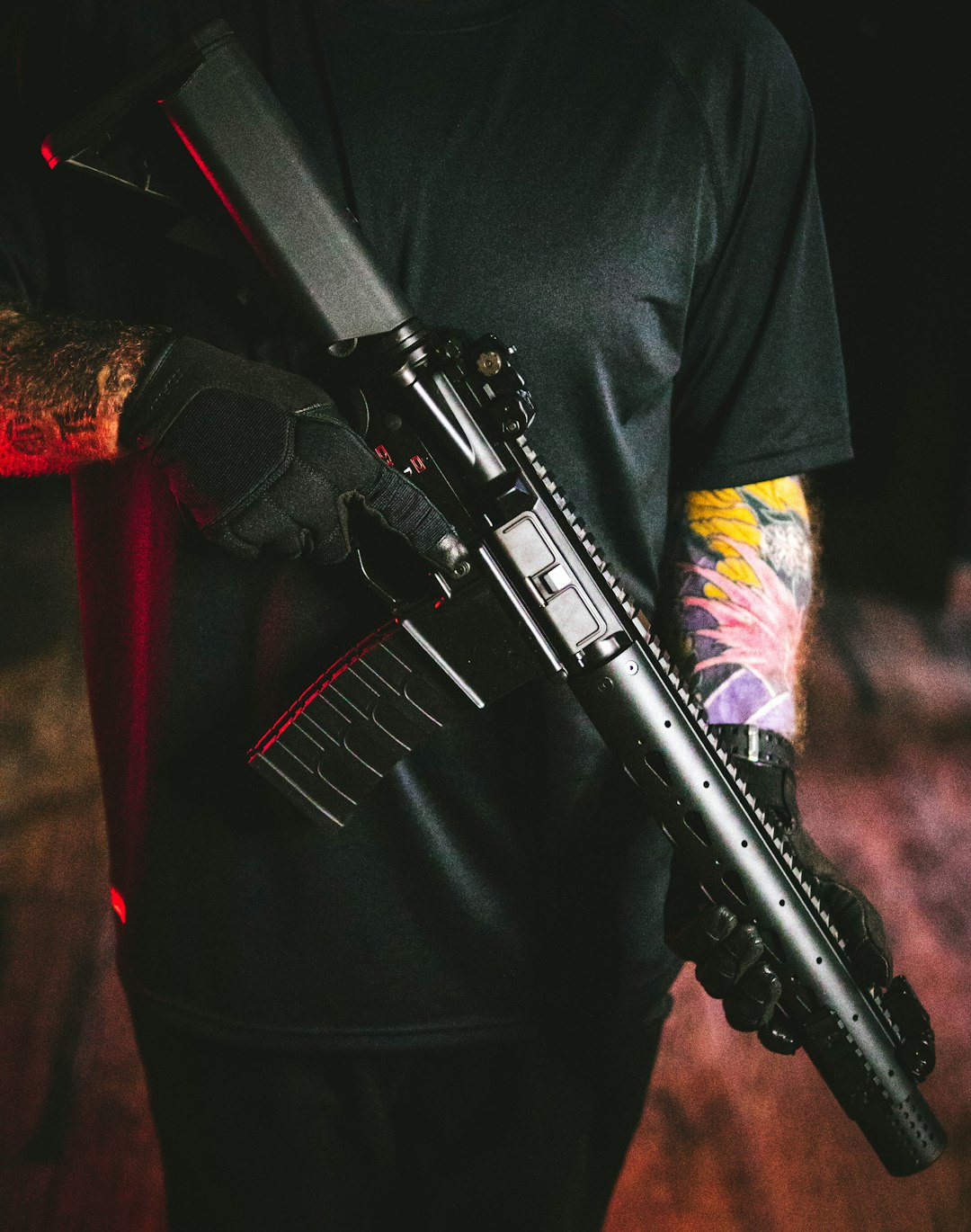 man in black long sleeve shirt holding black rifle