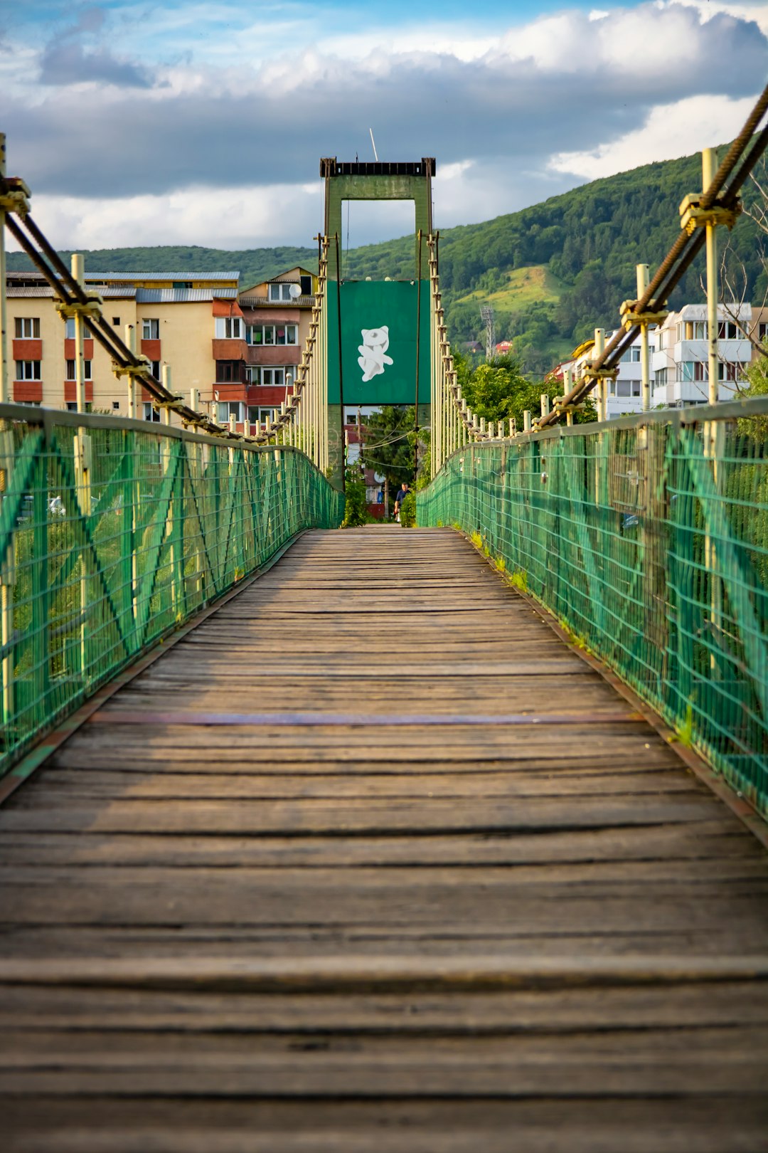 brown wooden bridge with green metal railings