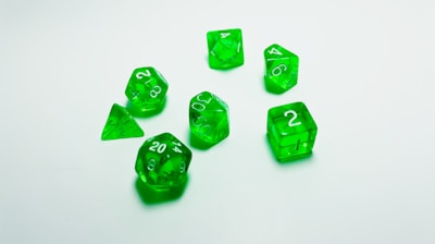 green plastic dice on white surface