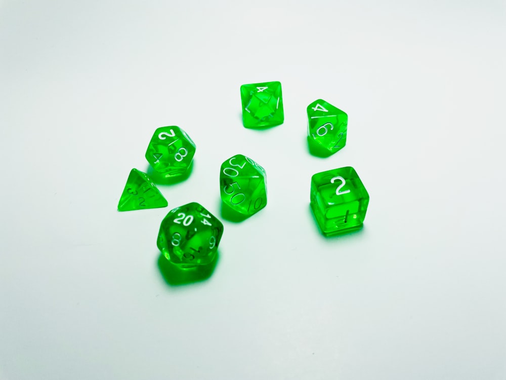 green plastic dice on white surface