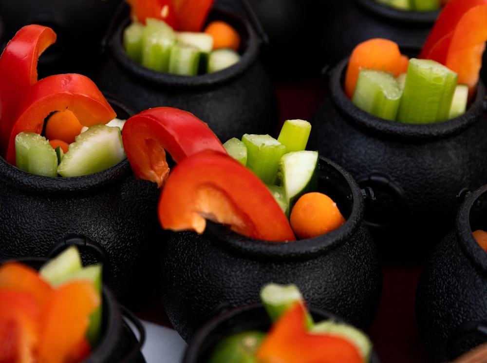 sliced tomato and green vegetable on black round plate