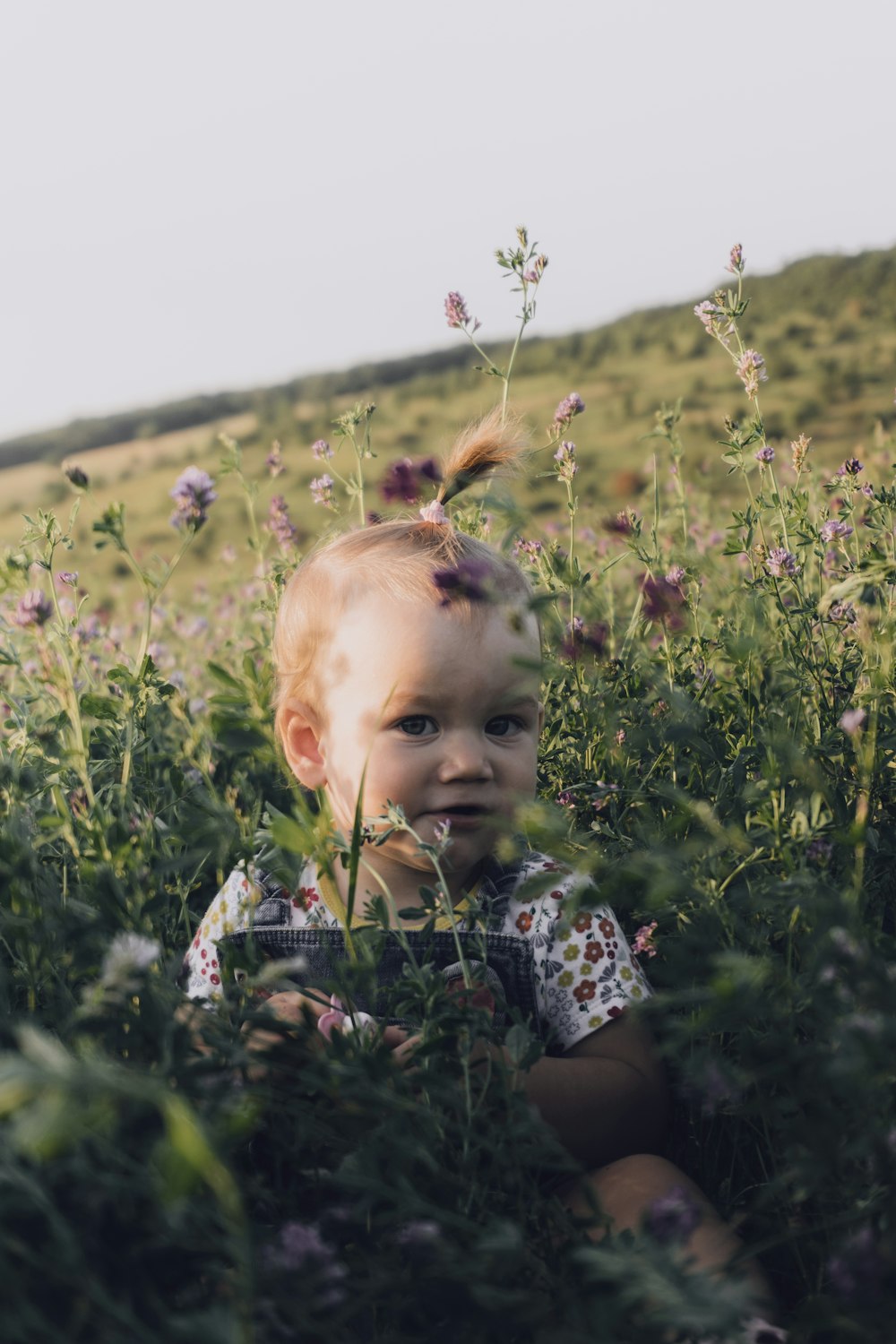 girl in blue and white floral dress on green grass field during daytime