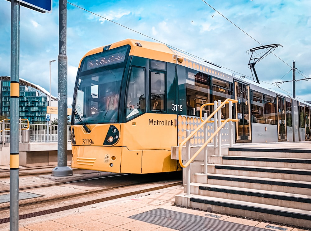 Tram giallo e bianco sulla stazione ferroviaria durante il giorno