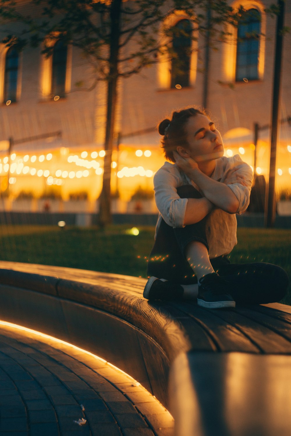 man in white dress shirt and black pants sitting on road during night time