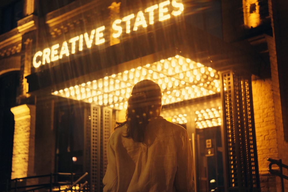 man in white dress shirt standing near glass window