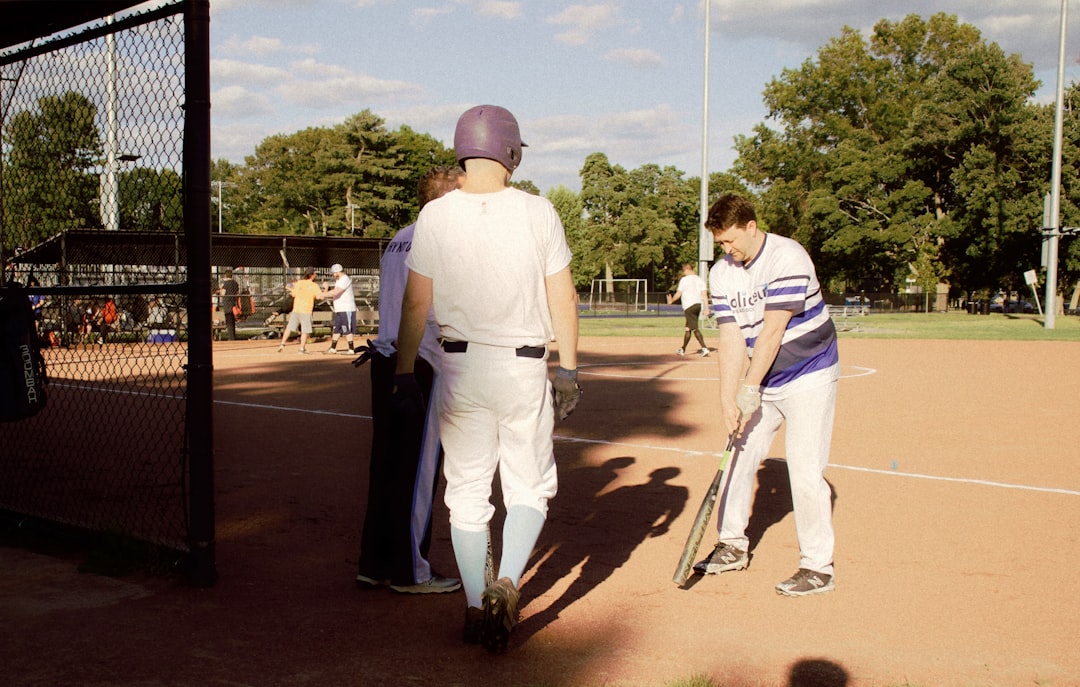 man in white shirt and pants holding baseball bat