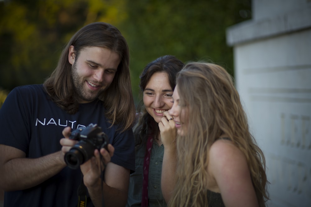 woman in black tank top holding black dslr camera