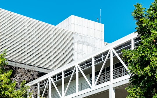 white metal frame near white concrete building during daytime in University of the West Indies Jamaica