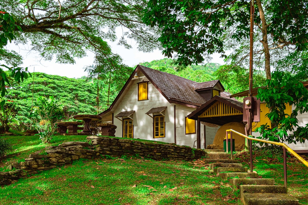 brown and white house surrounded by green trees during daytime