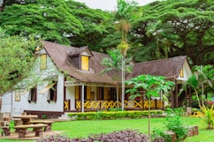 brown wooden house near green trees during daytime