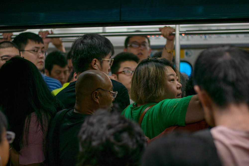 電車の中に座っている緑のシャツを着た人々