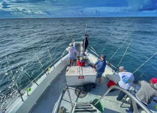 people riding on white boat during daytime