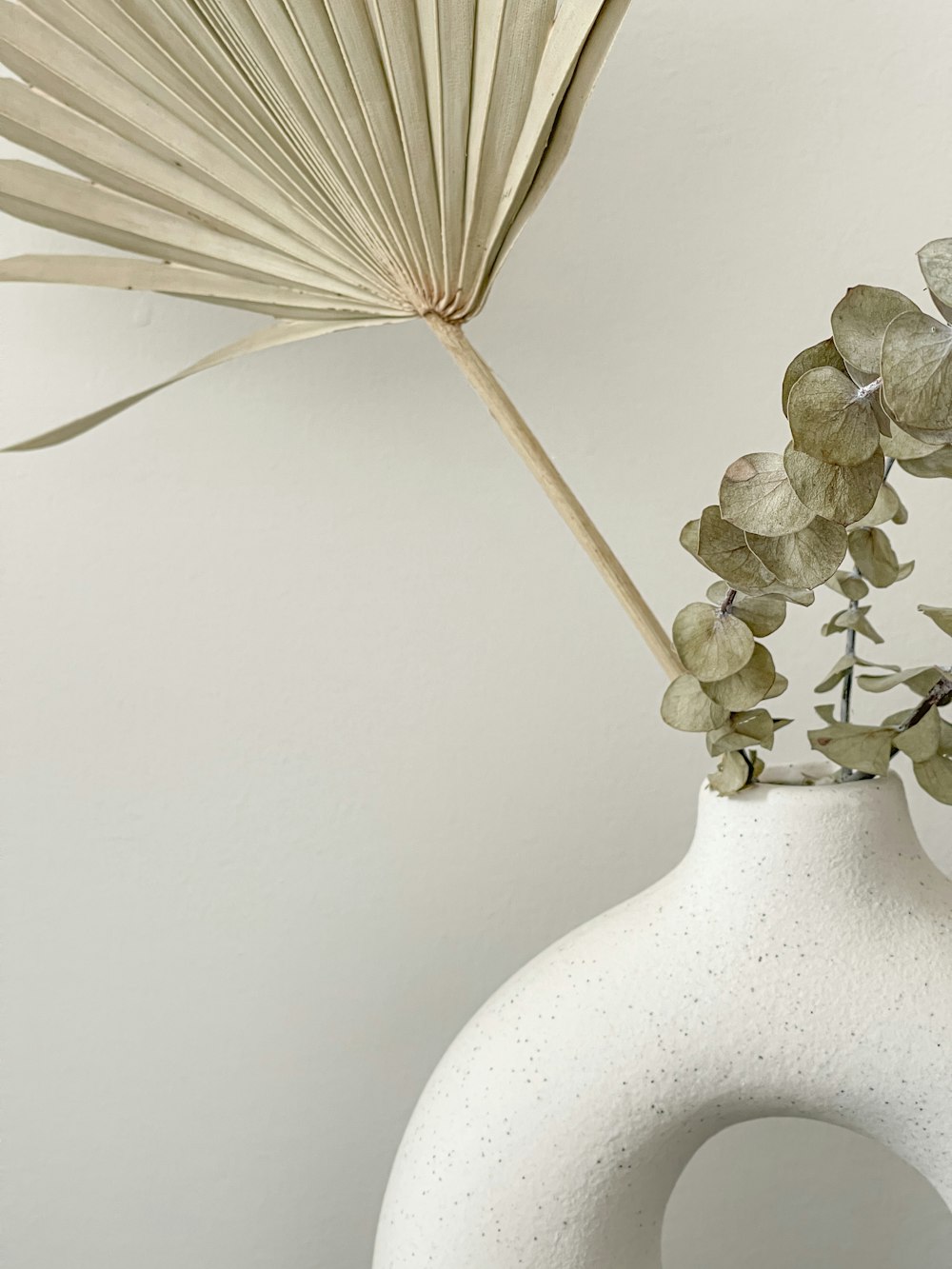 white flower in white ceramic vase