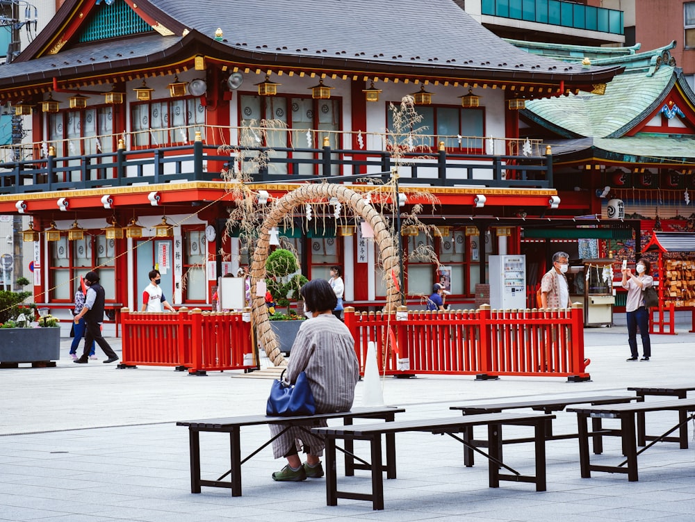 man in blue jacket sitting on black wooden bench