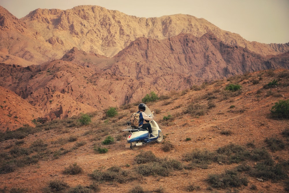 man in black jacket riding motorcycle on dirt road during daytime