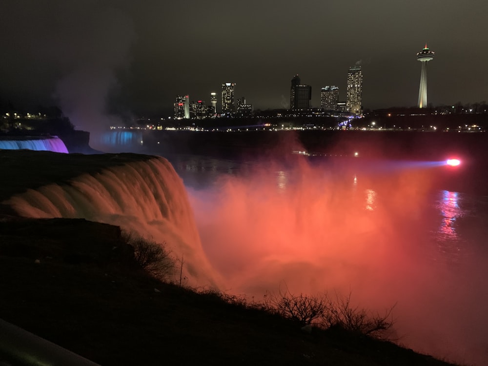 El agua cae cerca de los edificios de la ciudad durante la noche