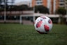 white red and blue soccer ball on green grass field during daytime