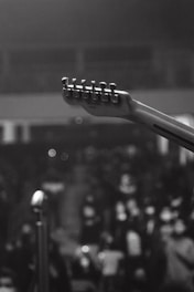 grayscale photo of person playing guitar