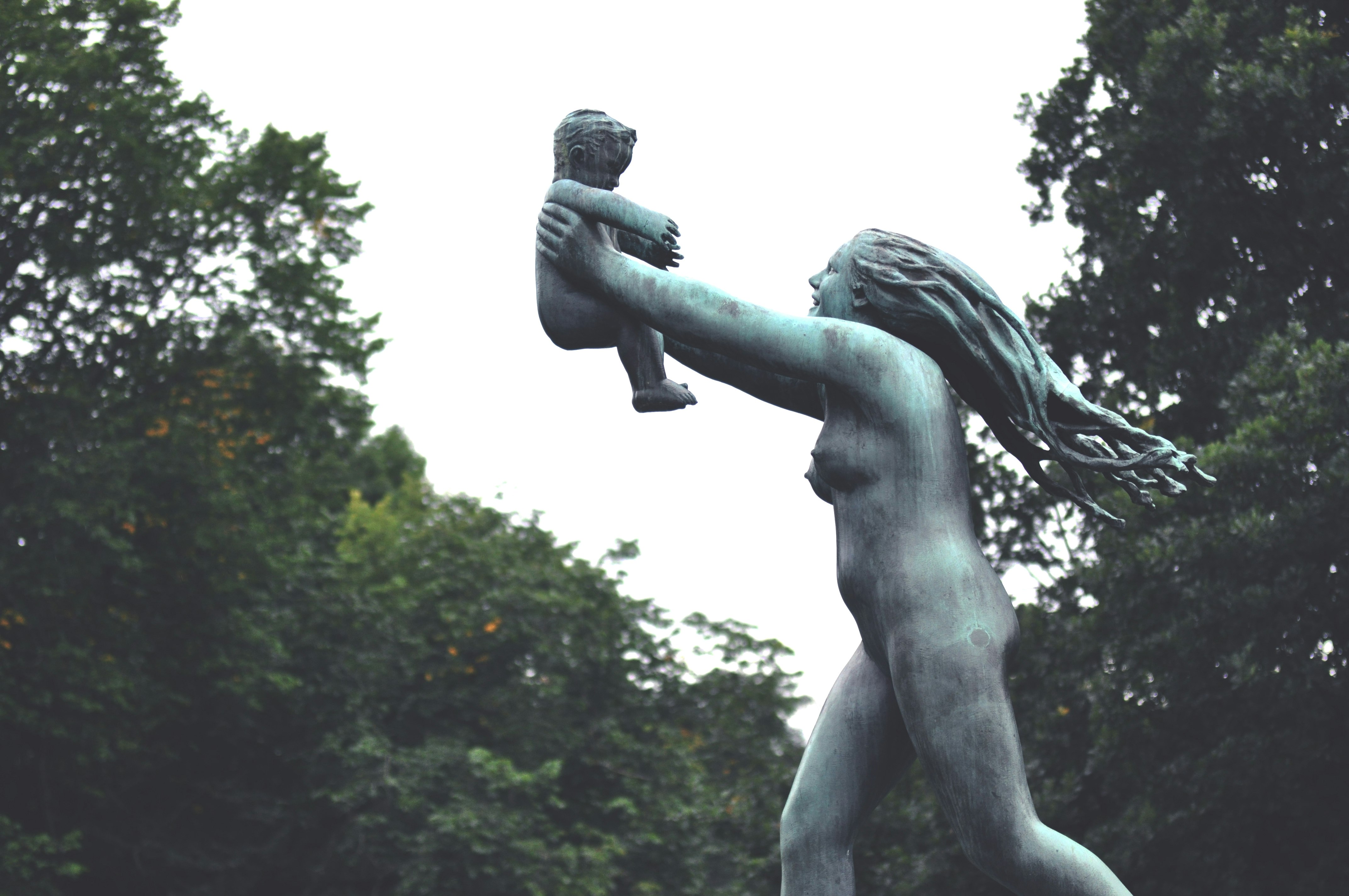 man holding a book statue