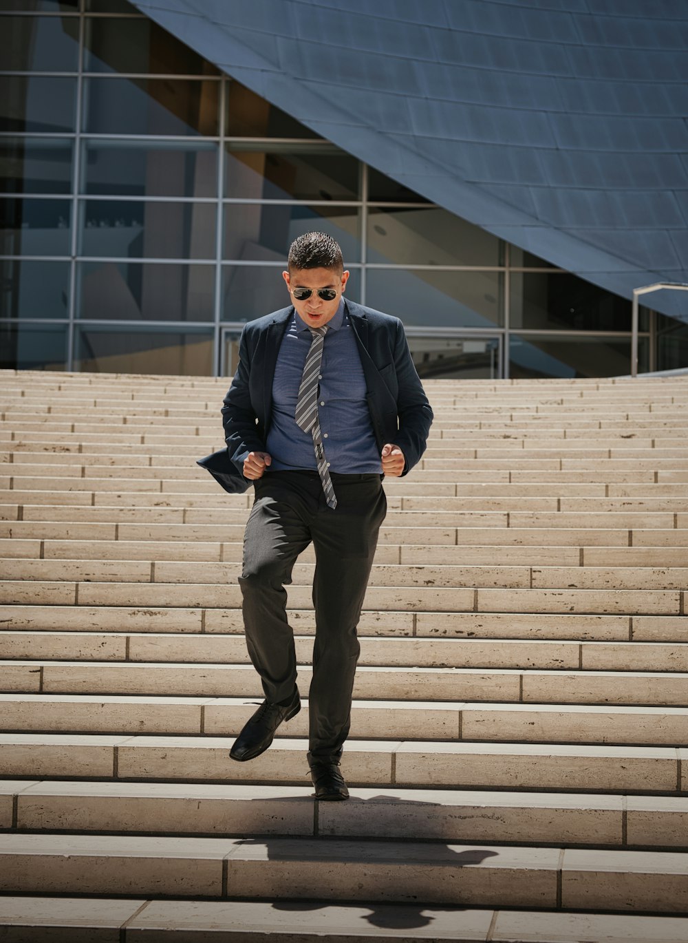 man in black coat standing on white concrete stairs