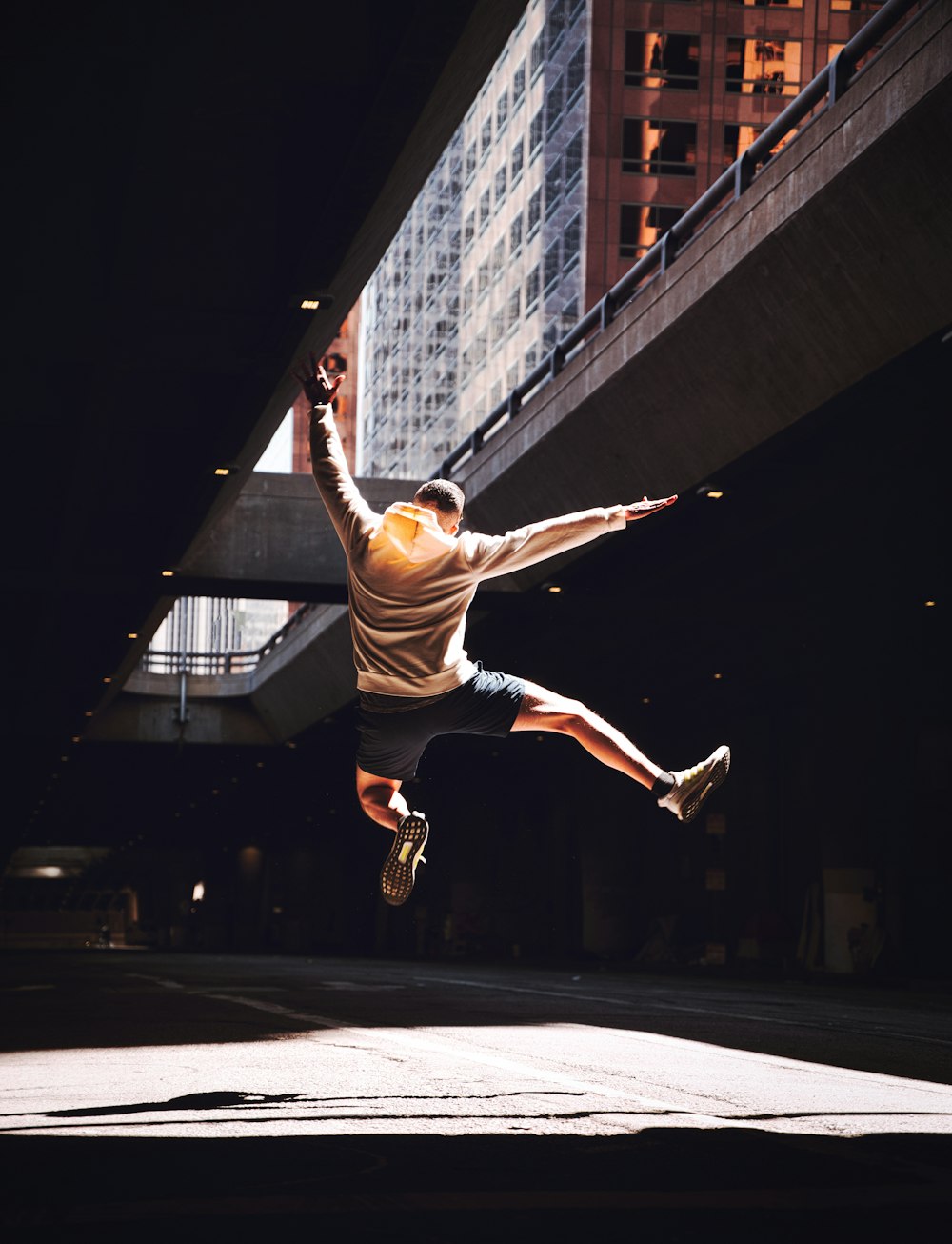 man in white and black stripe shirt and black shorts jumping on mid air