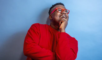 man in red sweater wearing black framed eyeglasses