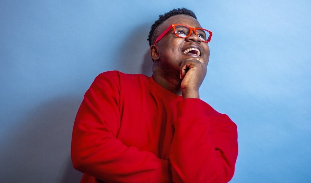 man in red sweater wearing black framed eyeglasses