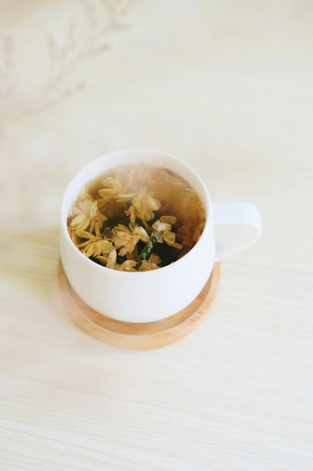 white ceramic mug with brown and green leaves