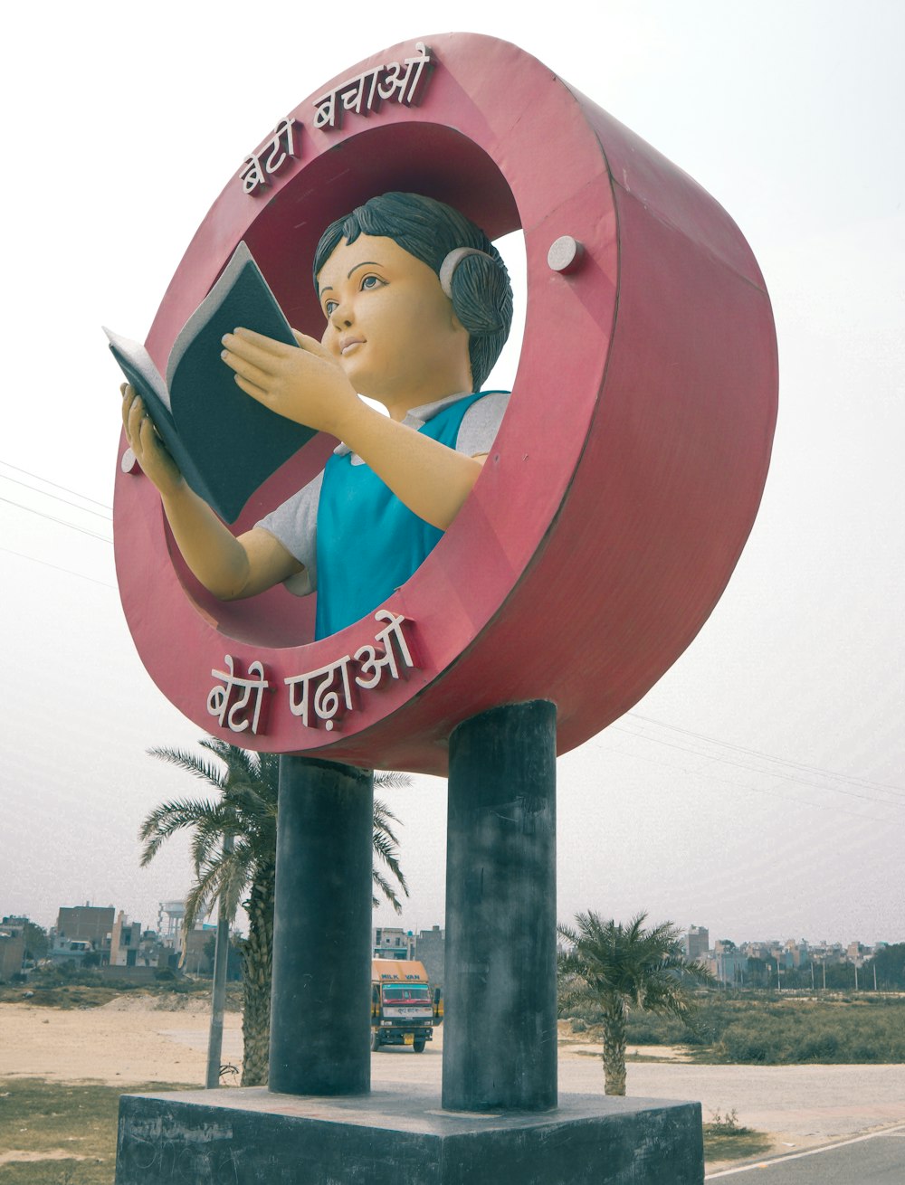 woman in blue shirt and black pants sitting on red round signage