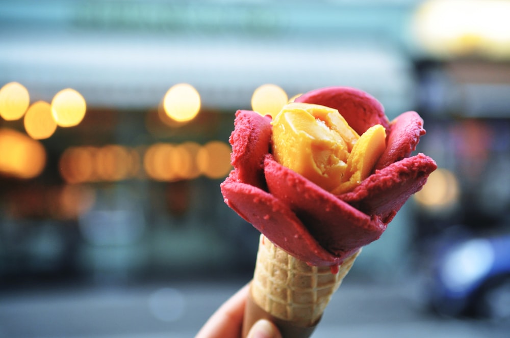 person holding ice cream cone with ice cream