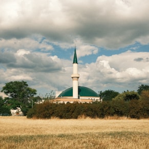 white and green concrete building under white clouds during daytime