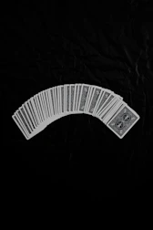 Bridge cards fanned out on a deep red velvet cloth with ancient Roman motifs.