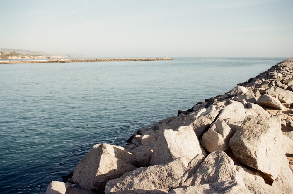 brown and gray rocks beside body of water during daytime