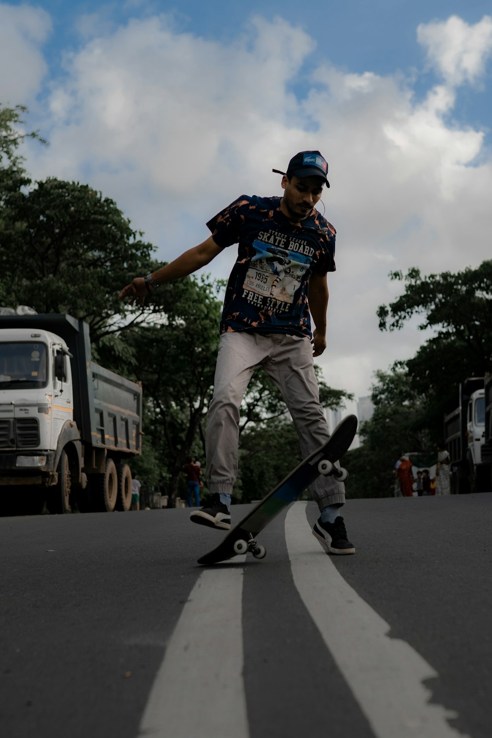 man in black and white crew neck t-shirt and white pants riding skateboard during daytime