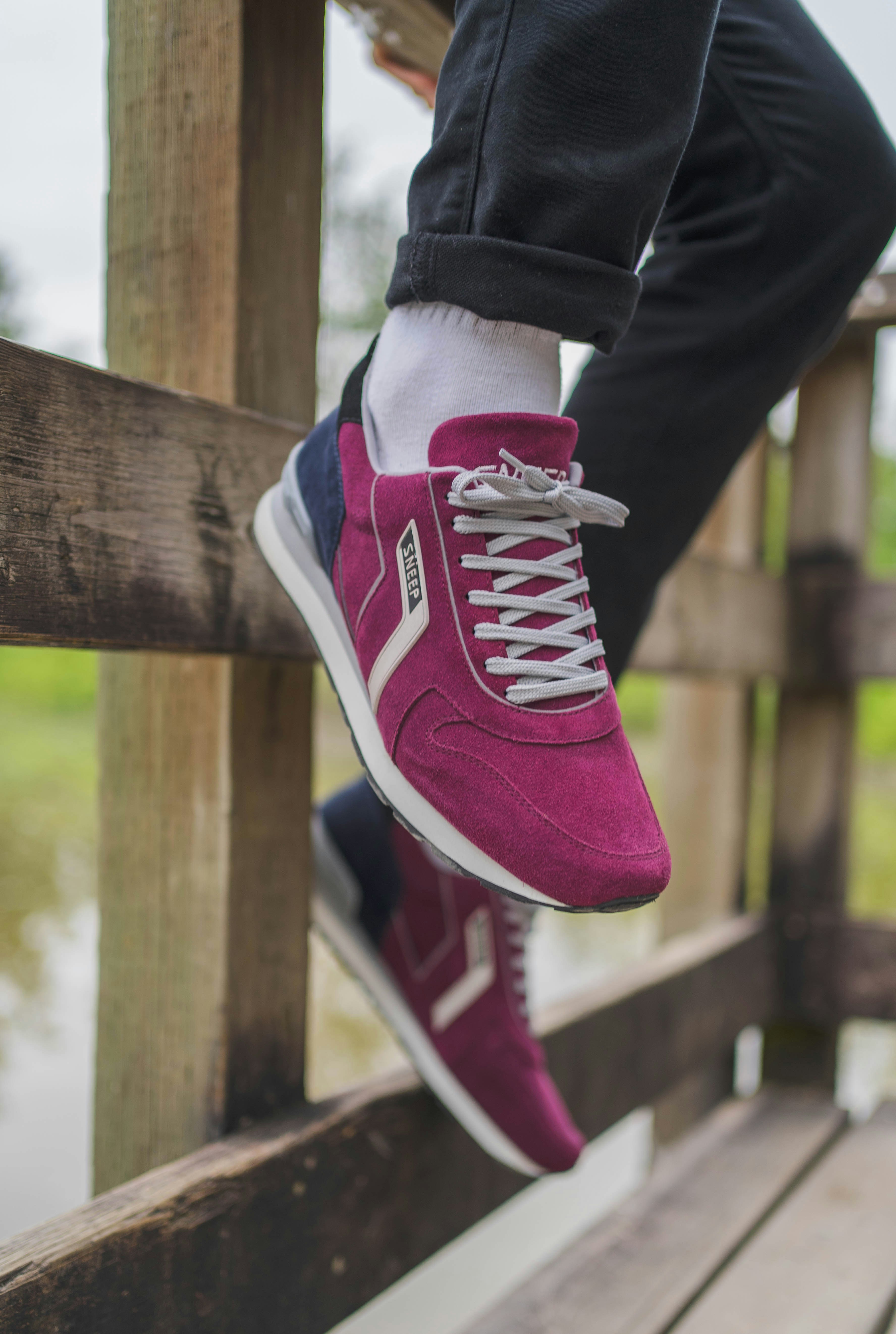 Person in lila und weißen Nike Sneakers