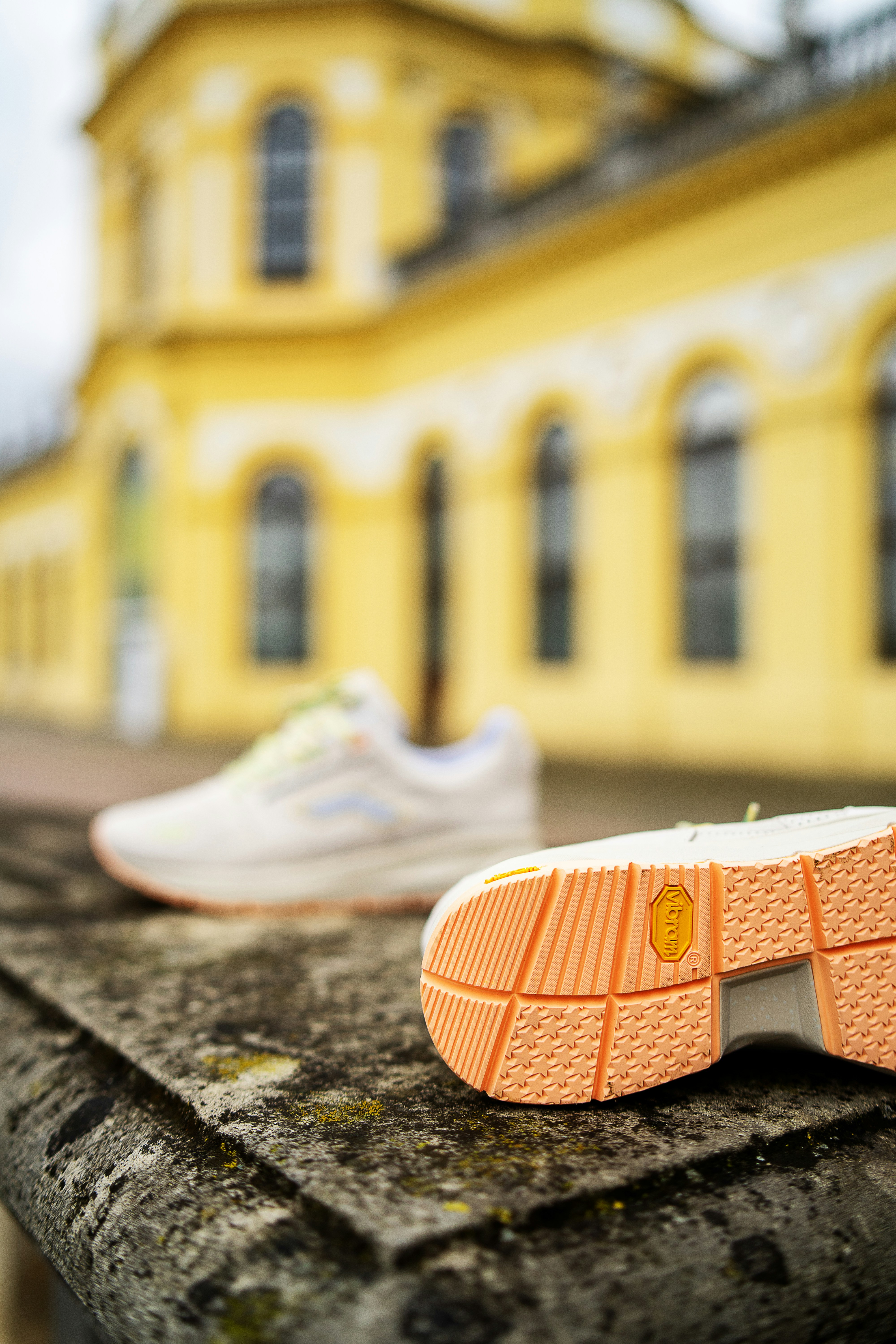 Weiße und orange Nike Sportschuhe auf grauem Betonboden