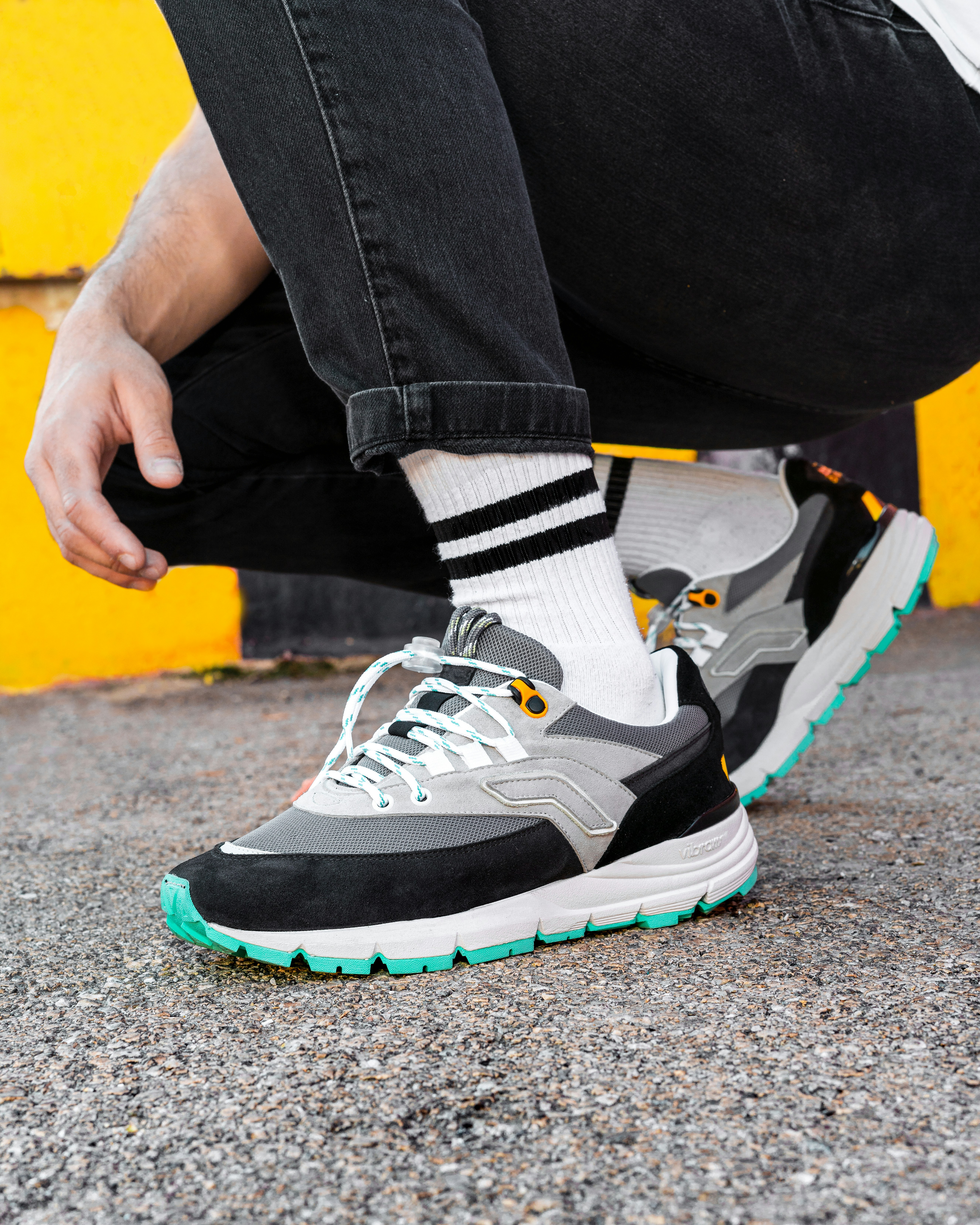 Personne portant des chaussures de sport Nike noires et blanches