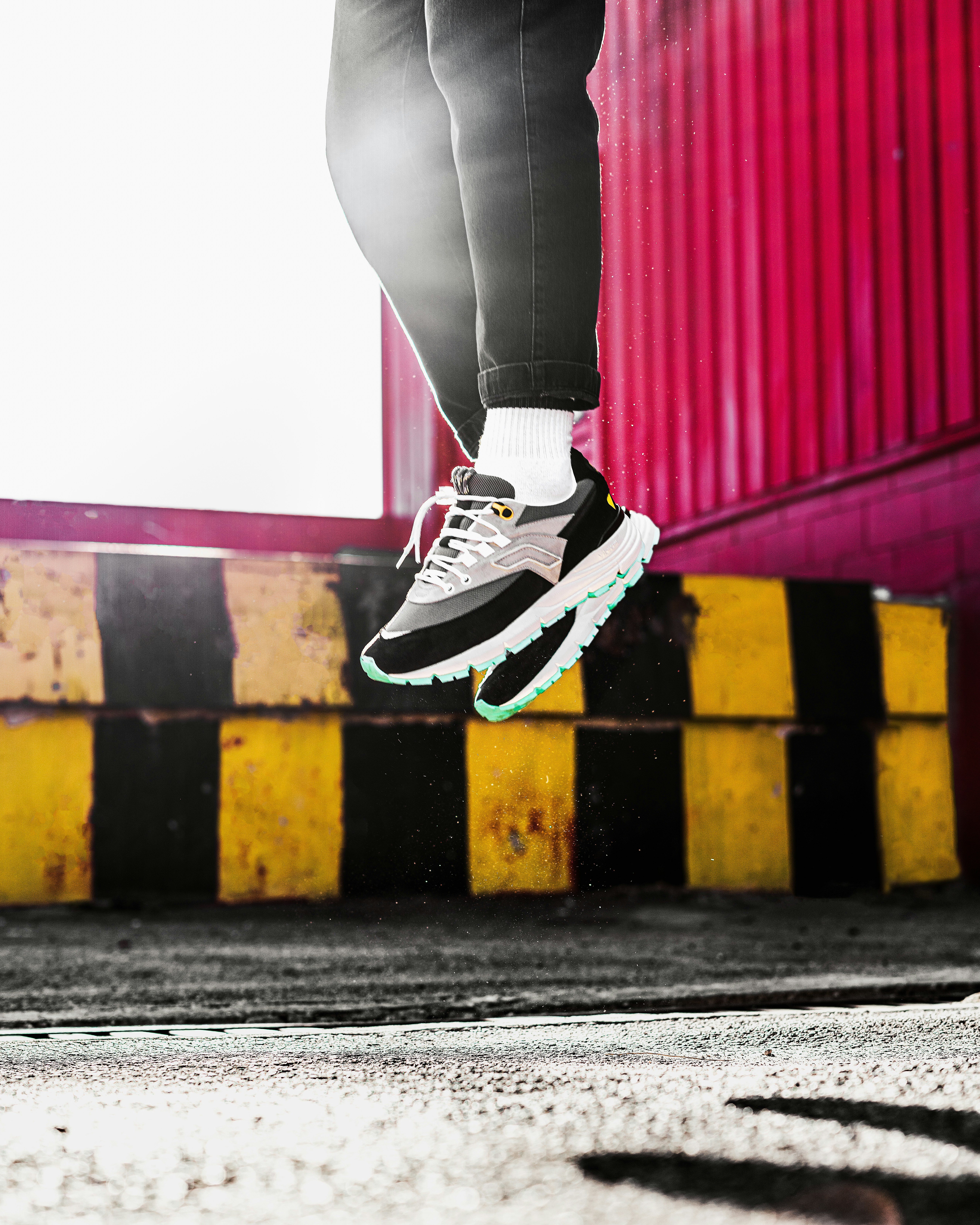 Person in schwarzen Hosen und schwarz-weißen Nike-Sneakers