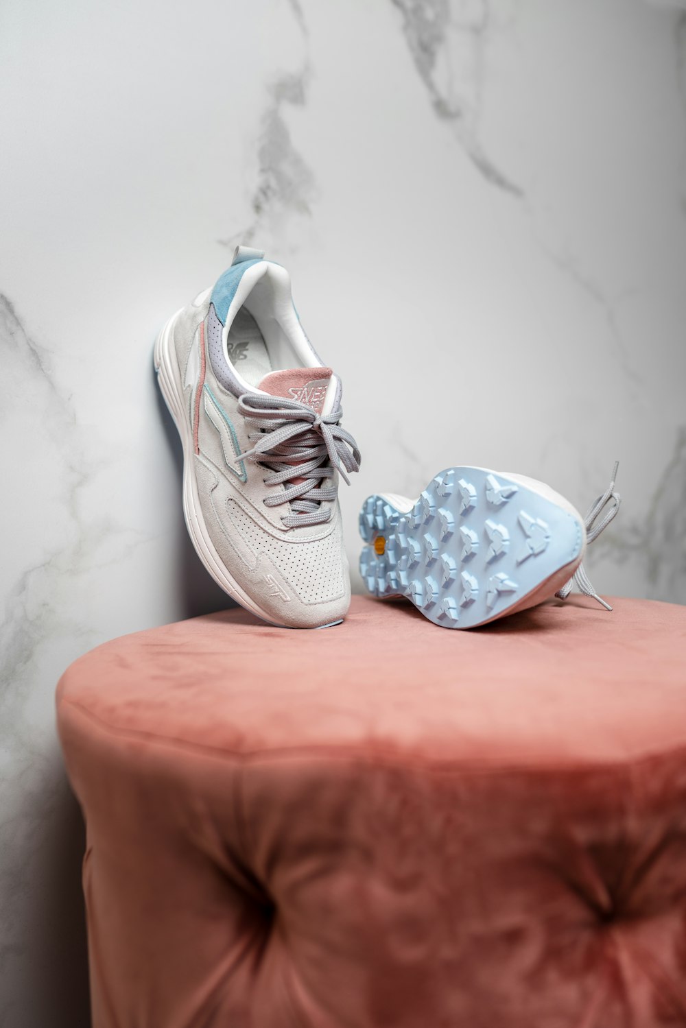 white and black nike athletic shoes on brown wooden seat