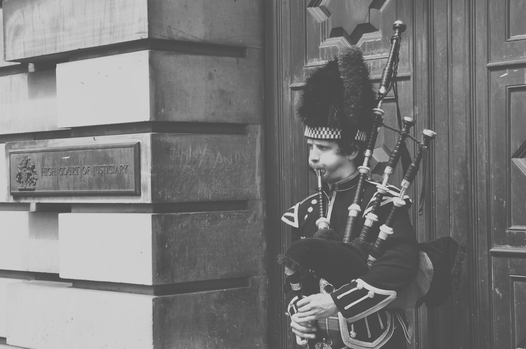 grayscale photo of man playing guitar