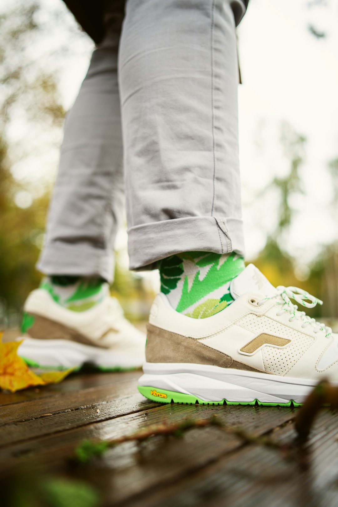 person in gray pants wearing green and white nike sneakers