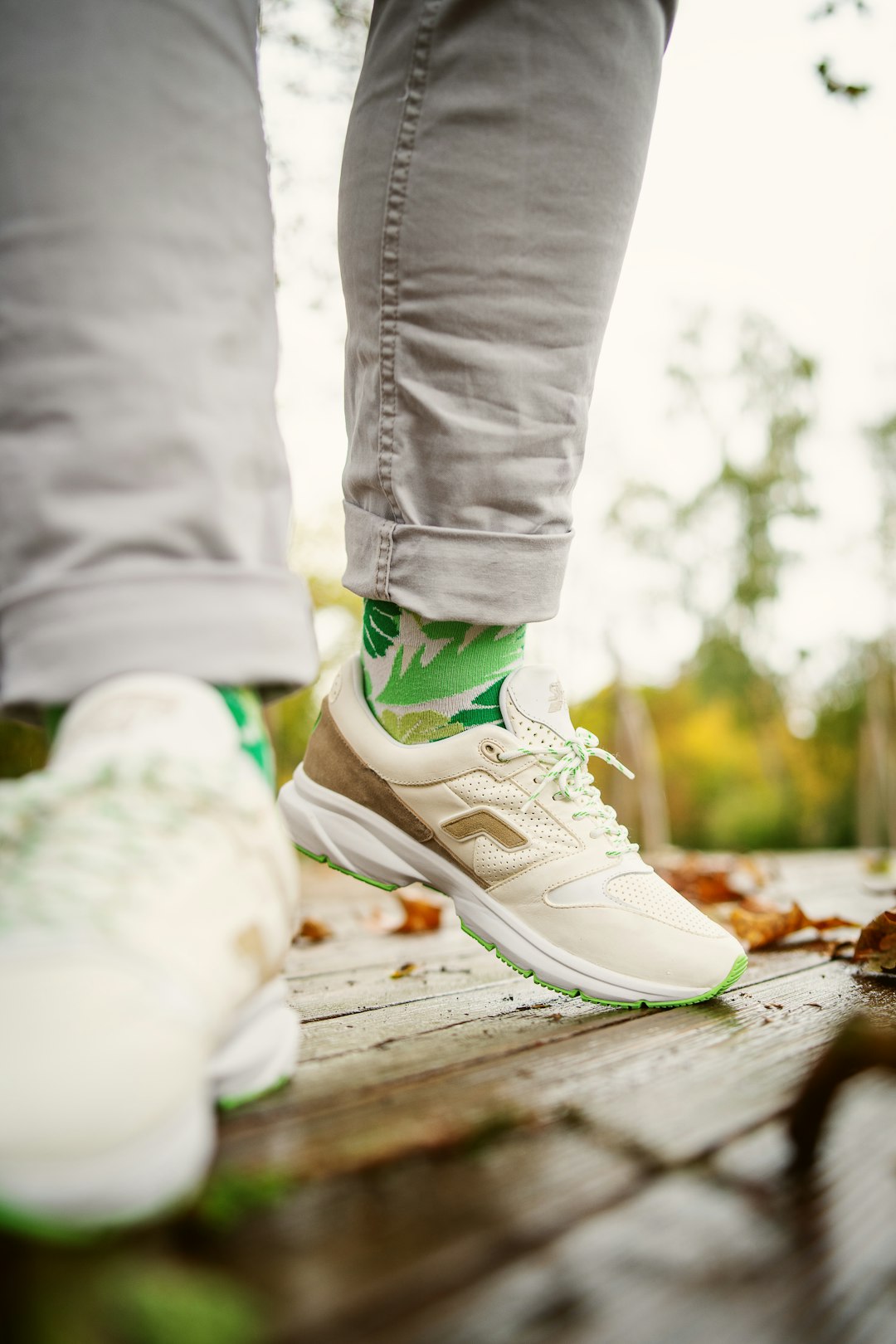 person in white pants wearing white and green nike sneakers