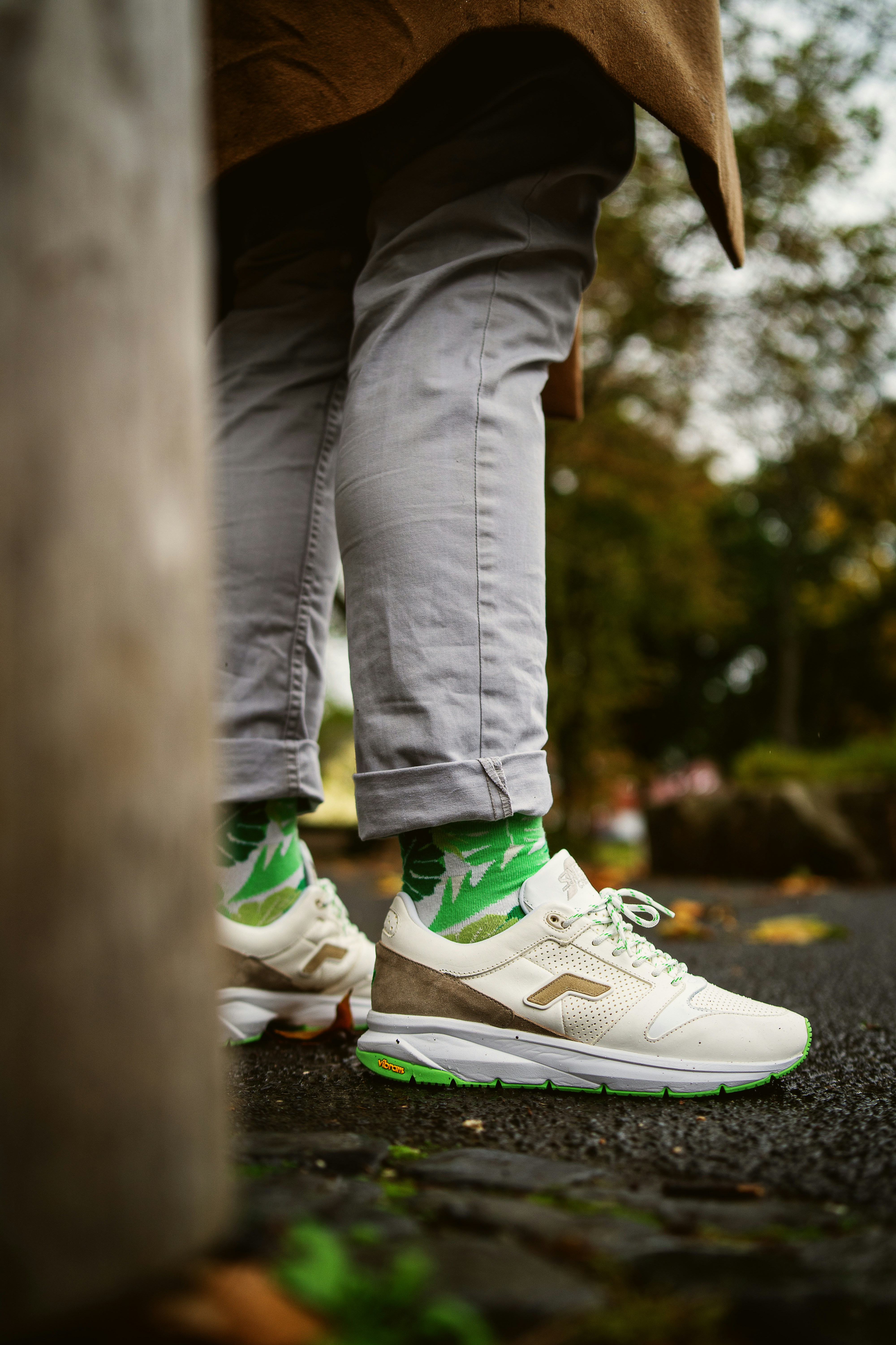 Persona con pantalones grises con zapatillas Nike verdes y blancas